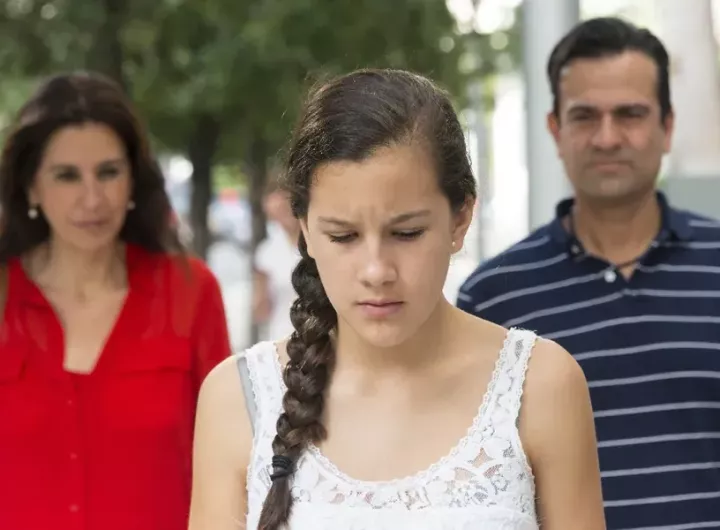 Sad teenage girl turns her back on her parents