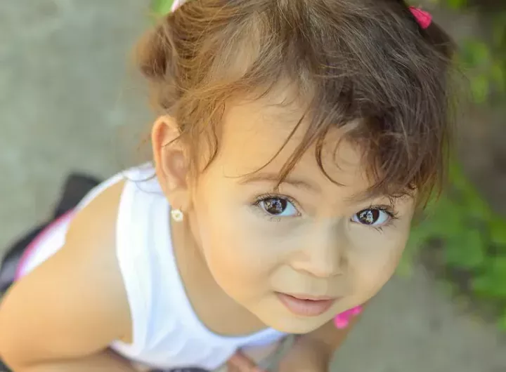 cute little girl looking upwards with trusting but confused expression