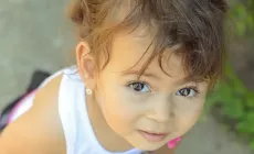 cute little girl looking upwards with trusting but confused expression