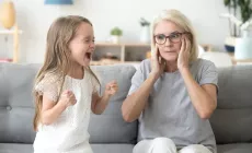 child screams while grandmother blocks ears