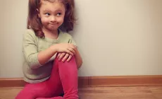 bemused little girl sitting on the floor