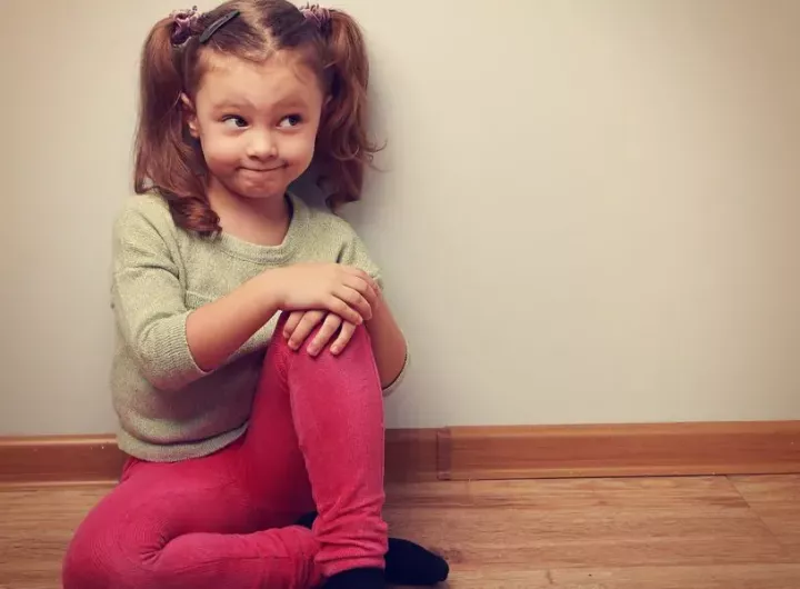 bemused little girl sitting on the floor