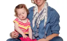 mother with daughter in her lap (child has Down Syndrome)